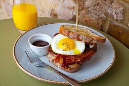 Bacon and fried egg sandwich, with white crusty bread and brown sauce