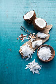 Still life with halved coconut, desiccated coconut, and coconut shavings