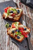 Slices of raisin bread with marinated mozzarella, blueberries, and red currants