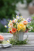 Kleiner Strauß aus Rosenblüten, Kamille, Katzenminze und Holunderknospen in Graskranz