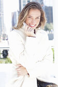 Joyful woman in white coat