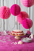 Festliche Himbeer-Sahne-Torte, darüber Partydeko in Pink