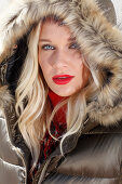 Blonde Frau in Winterjacke mit Fellkapuze