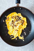 Scrambled eggs with mushrooms and mustard in a pan