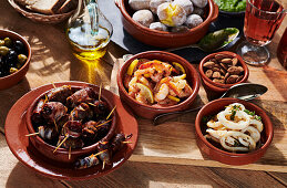 Tapas - dates wrapped in bacon, prawns, boiled potatoes, and squid