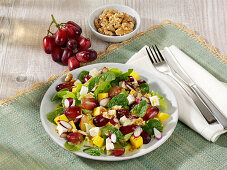 Fruity salad with lettuce, mango, grapes, goat's cheese and walnuts