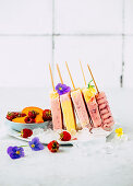 Raspberry and apricot ice cream on a stick