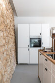 Kitchen with natural stone wall in an open room