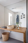 Bathroom with a rustic wooden bathroom counter with stone sink and mirrored wall in bathroom