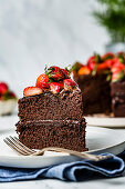 A chocolate cake decorated with fresh chopped strawberries