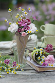 Small bouquets of carnation flowers and camomile in homemade paper cones