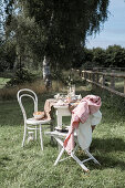 Easter table with linen tablecloth and chairs in the garden