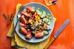 Cucumber and tomato salad with corn, olives and feta