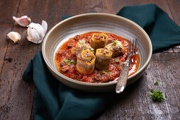 Yellow courgette rolls filled with vegan 'mince' on tomato sauce