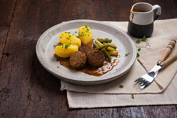 Vegan falafel with potatoes, yellow and green beans and sauce