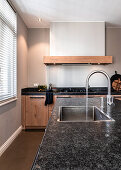 Custom-made kitchen in rustic oak with iron handles and granite top