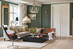 Mix of styles in the living room with coffered walls in dark green