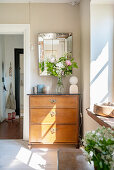 Old chest of drawers and nostalgic mirror at the window