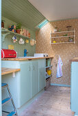 Vintage-style kitchen in mint green with floral wallpaper and flea-market finds