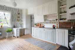 Light country kitchen with wallpaper and wooden floorboards