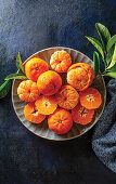 Mandarinen in Schale auf dunklem Untergrund