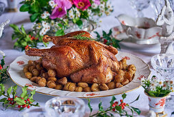 Roast chicken with chestnuts on a festively decorated table