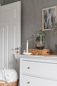 White chest of drawers against grey wall in bedroom