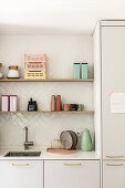 White kitchen units and shelves on tiled wall