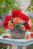 Bouquet of dahlias, rose petals and hydrangea flowers in a basket