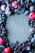 Autumn fruit in red and blue, arranged in a circle