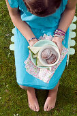 A girl holding a plate with chocolat cookies on a picknic