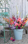 Bouquet of gladioli in an enamelled bucket