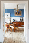 Looking into the dining room with oval table, sideboard, and chandelier with Christmas decoration