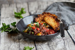 Bean-free chili con carne with sour cream, tomatoes and tortilla