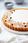 A cream cheese cake with pomegranate seeds and white currants