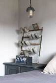 Alter blauer Schrank als Nachttisch darauf ein verwitterter Ständer mit emaillierten Gefäßen im Schlafzimmer