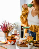 Bratäpfel und Schälchen mit Keksen, Frau mit einer Tasse Tee dahinter