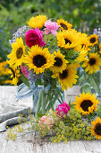 A bouquet of sunflowers with roses, borage and fennel blossoms