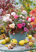 Autumn bouquet with roses, rose hips and autumn asters, quinces and chestnuts as decoration