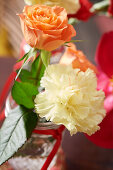 Lachsfarbene Rose und weiße Nelke als Tischdekoration