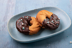 Vegan shortbread cookies with raspberry jam, dipped in chocolate icing and sprinkles