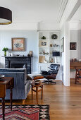 Living room with a classic lounge chair in front of shelves and fireplace