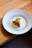 Poached egg with white and purple cauliflower in chive cream