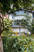 Blick vom Garten auf Holzhaus mit Sprossenfenster