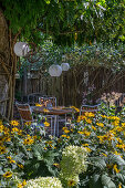 Sitzplatz mit Laternen in blühendem Garten