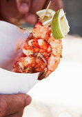 Grilled prawn skewers in a paper cone