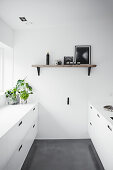 Minimalist kitchen in white with a grey concrete floor