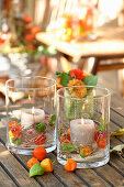 Candle lanterns decorated with physalis and spindle seed heads