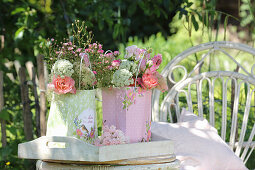 Small bouquets of outdoor roses, peonies and rambler roses with wild carrot and scabiosa in paper bags