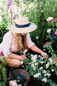 Frau bei der Gartenarbeit in blühendem Garten